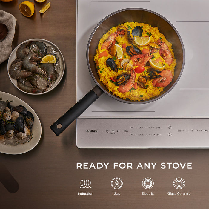 A Cuckoo pan on a stovetop, demonstrating its compatibility with induction, gas, electric, and glass ceramic stoves. (COP-B2810HGB)