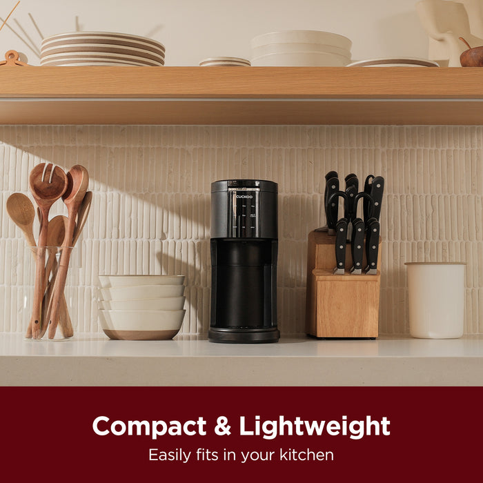 Black CUCKOO K-Cup single-serve coffee maker on a counter, highlighting its compact and lightweight space-saving design. (CCM-AK011B)