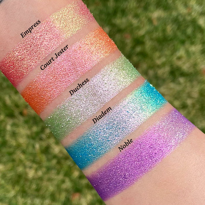 Top angled arm swatches on fair skin tone of Duchess Glitter Vibrant Multichrome Eyeshadow shifts compared to Empress, Court Jester, Diadem and Noble