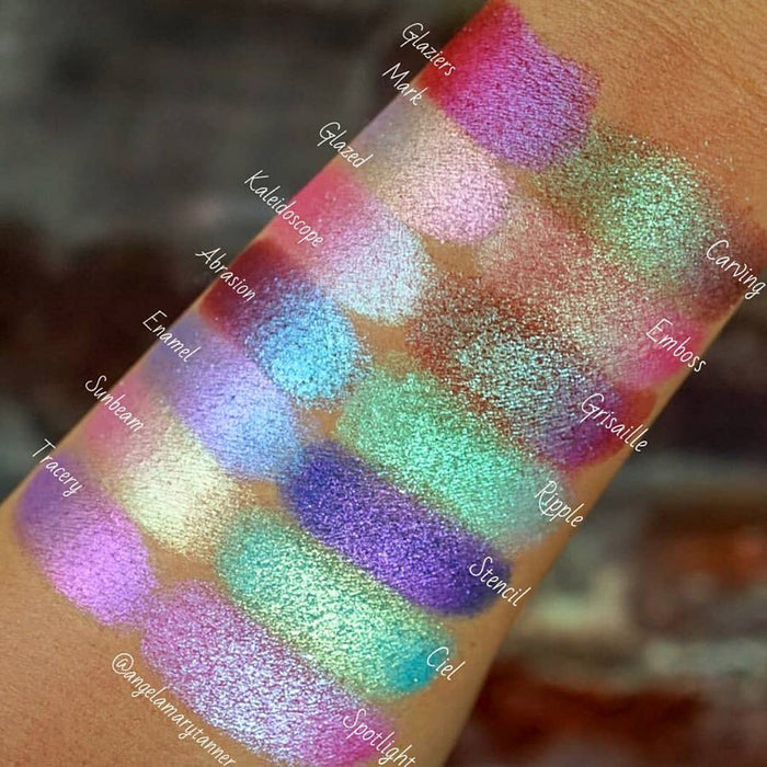 Top angled arm swatches on medium skin tone of Glazed Glitter Multichrome Eyeshadow shifts compared to Glaziers Mark, Kaleidoscope, Abrasion, Enamel, Sunbeam, Tracery, Carving, Emboss, Grisaille, Ripple, Stencil, Ciel, Spotlight