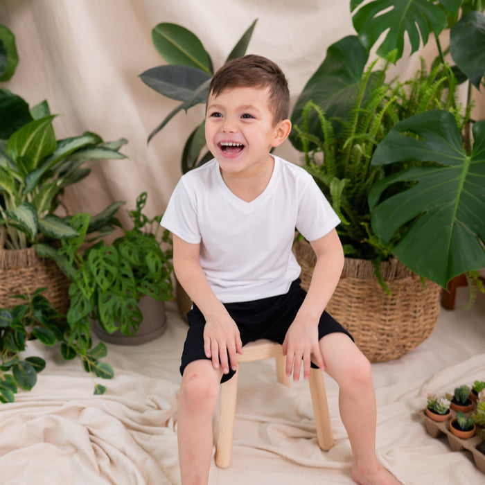Toddler wearing Kyte Baby Harem Shorts with cuffed edges in Midnight black
