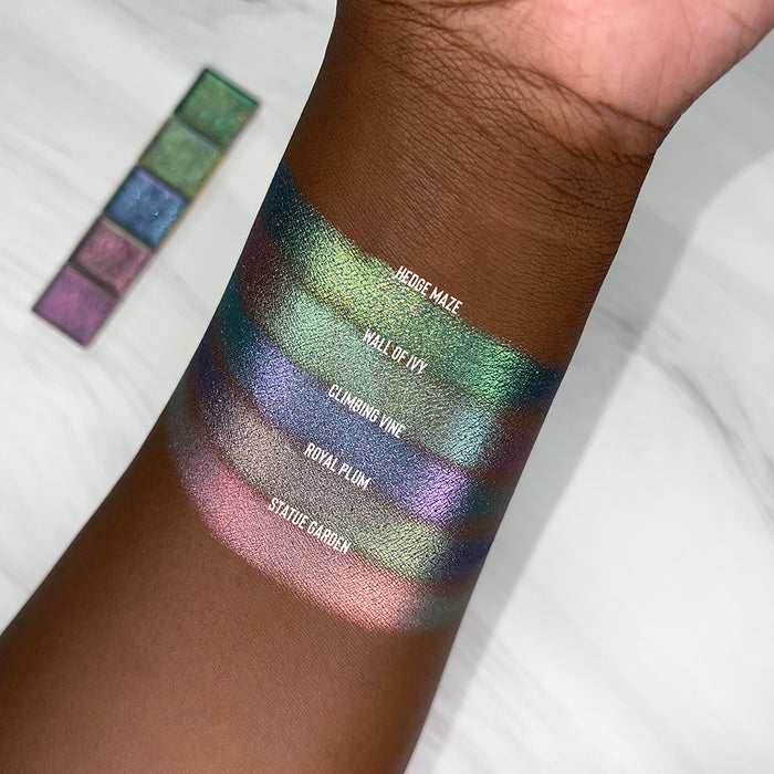 Top angled arm swatches on deep skin tone of Hedge Maze Earth Vibrant Multichrome shifts compared to Wall of Ivy, Climbing Vine, Royal Plum and Statue Garden