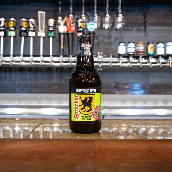 Honeycrisp apple soda bottle on a bar counter with beer taps in the background