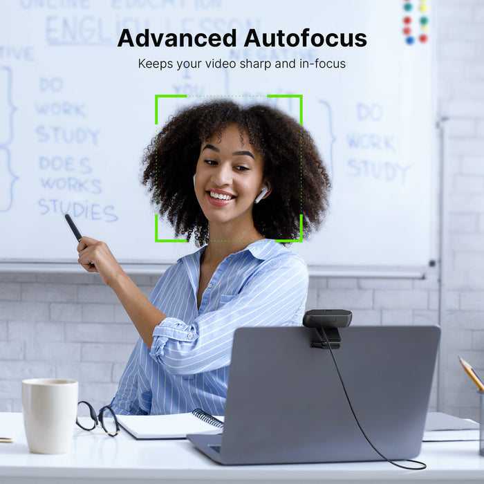 A woman is attending a meeting using a webcam with autofocus.