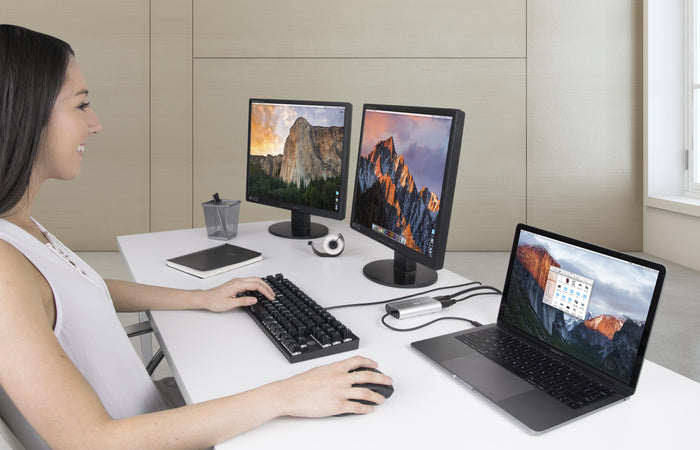 Plugable TBT3-DP2X-83 Thunderbolt 3 adapter connecting a MacBook Pro to two external DisplayPort monitors.