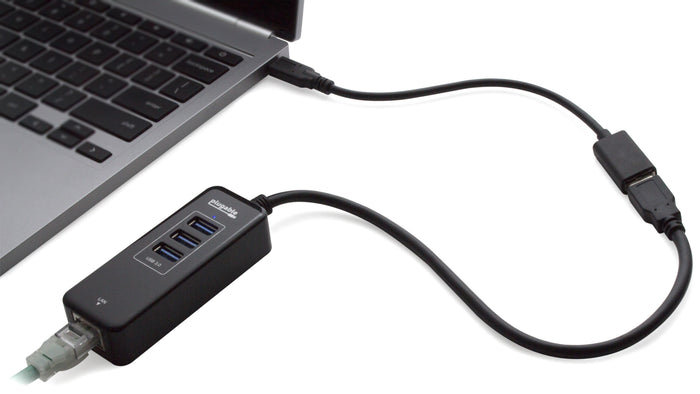 Plugable hub with three USB 3.0 ports and one LAN port connected to a laptop via USB-C cable.