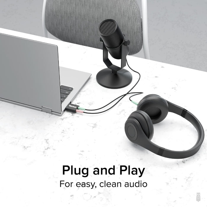 Plugable USB-AUDIO adapter connected to a laptop, providing separate 3.5mm microphone and headphone ports.