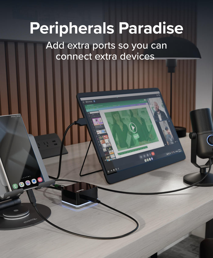 Plugable UD-CUBE mini docking station connecting a smartphone, external monitor, and microphone on a desk.