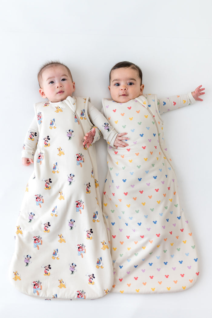 2 babies wearing sleep sacks in mickey mouse patterns