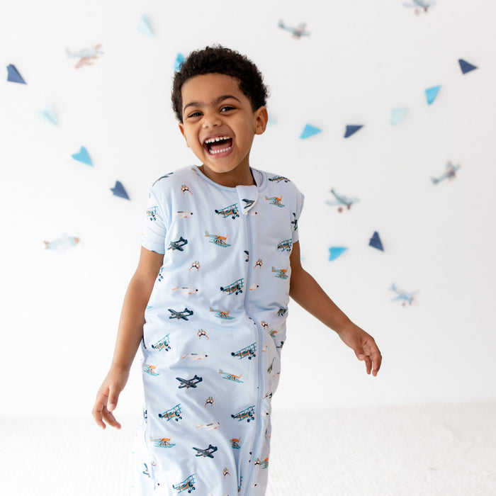 Smiling boy walking wearing the Sleep Bag Walker in Take Off 1.0