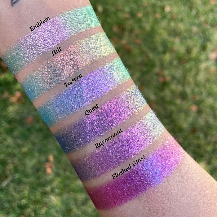 Top angled arm swatches on fair skin tone of Tessera Electric Mulitchrome Eyeshadow shifts compared to Emblem, Hilt, Quest, Rayonnant and Flashed Glass