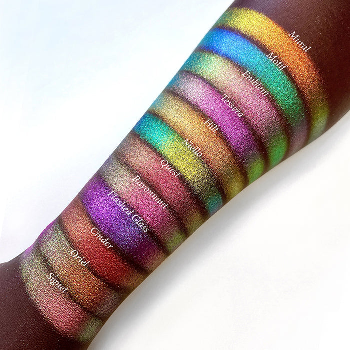 Top angled arm swatches on deep skin tone of Tessera Electric Multichrome shifts compared to Mural, Motif, Emblem, Hilt, Niello, Quest, Rayonnant, Flashed Glass, Cinder, Oriel and SIgnet