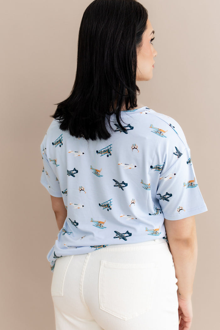The back of the Women's Relaxed Fit V-Neck in Take Off shown on a model paired with cream pants