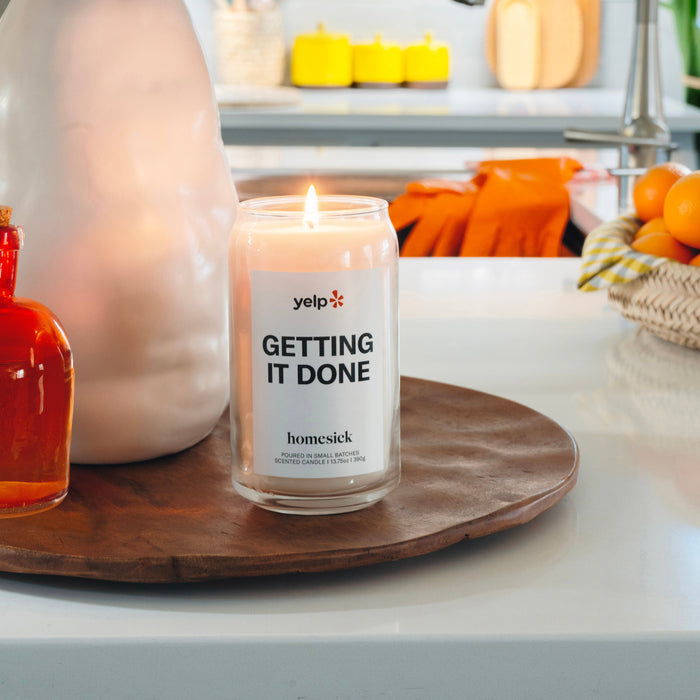 A lit Getting It Done candle in a clean environment