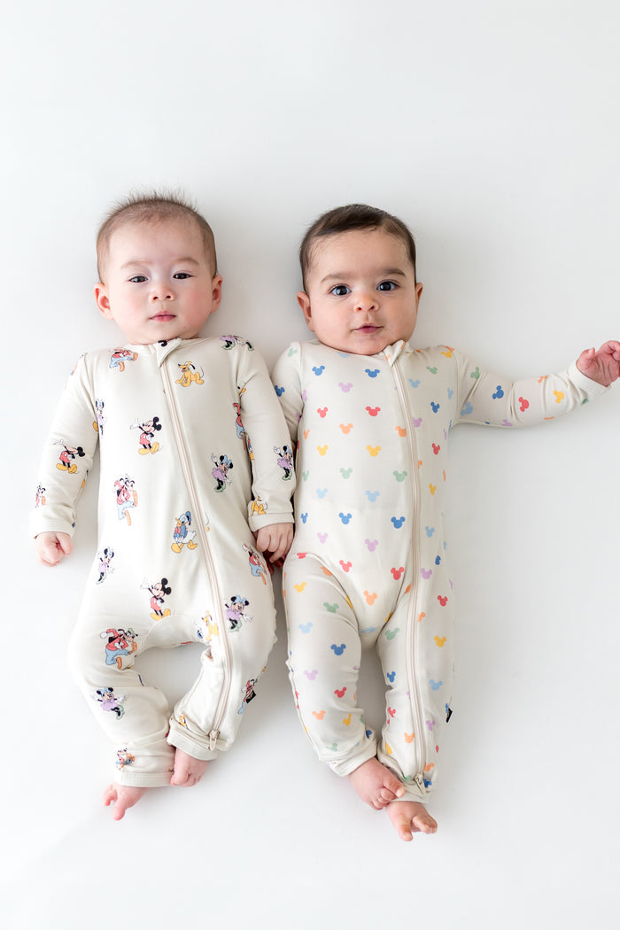 2 babies wearing zippered rompers in mickey mouse patterns